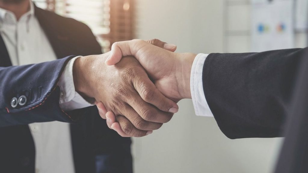 Two confident business man shaking hands during a meeting in the office, success, dealing, greeting and partner concept.